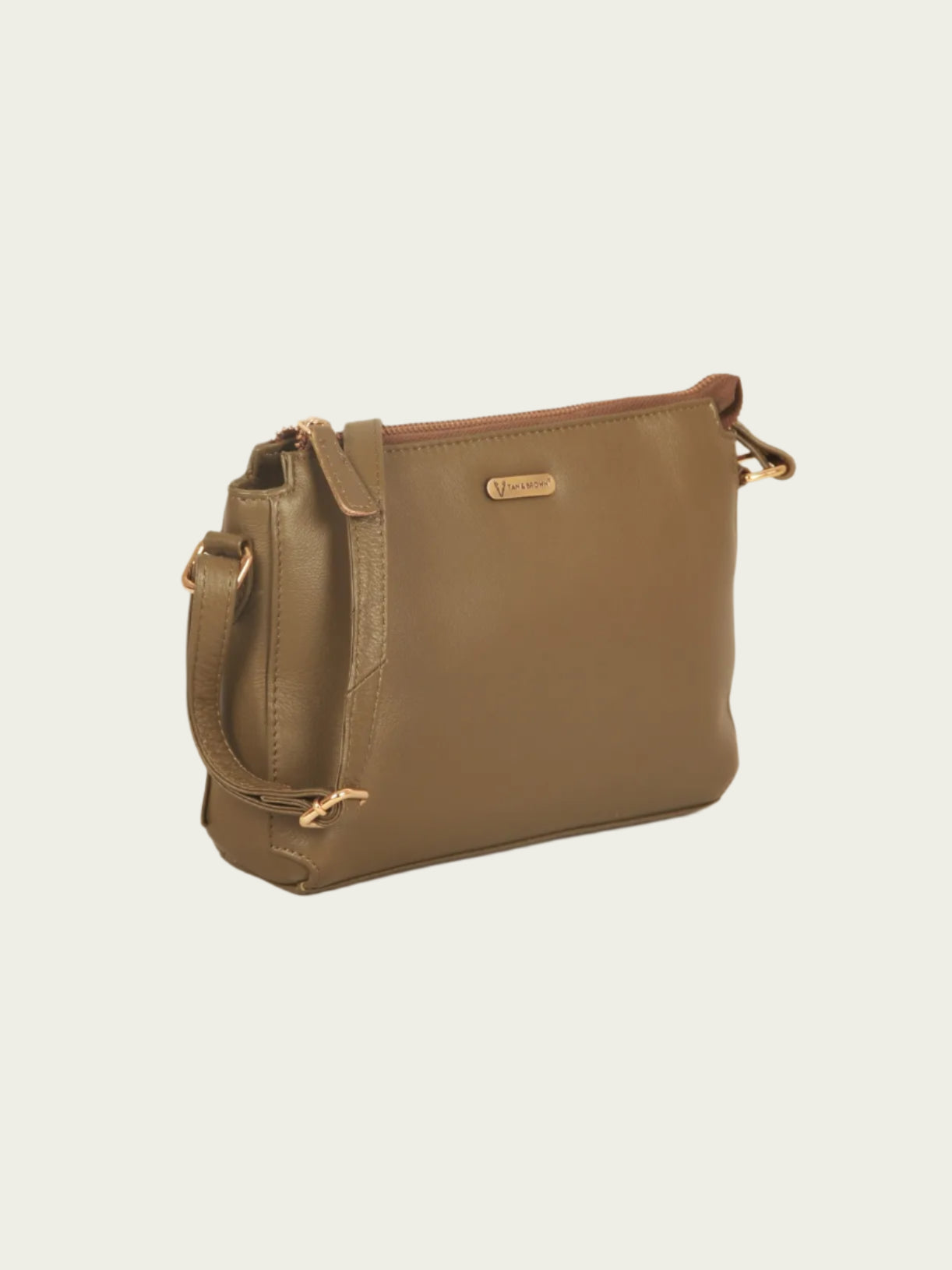 Green leather handbag with gold accents on a beige background